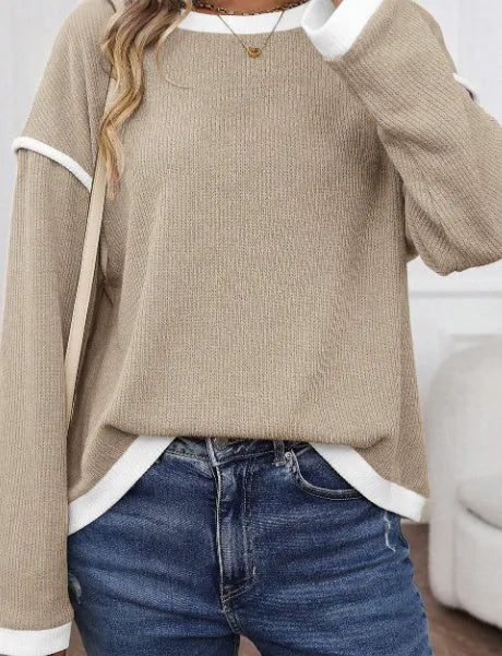 Woman wearing a green four leaf clover pattern loose knit top with drop shoulders and contrast trim