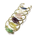 Natural rough crystal bracelet with geometric gold metal winding on a wrist.