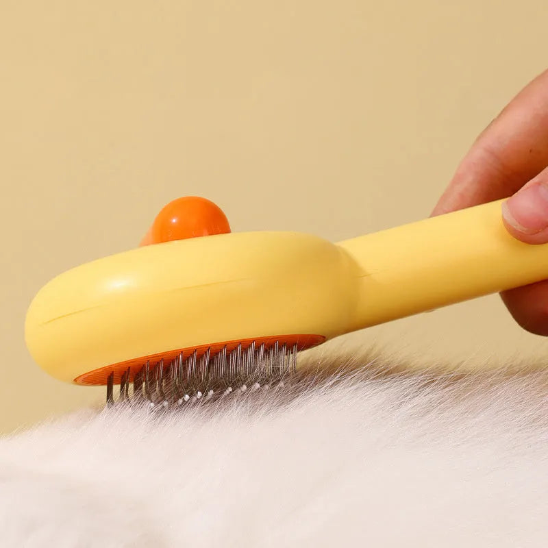 Small yellow duck-shaped pet comb with open sections and floating needles for cat and dog hair removal