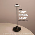 Gold UFO-shaped metal table lamp with touch dimming controls on a desk.