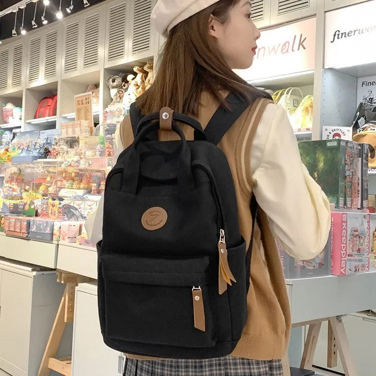 Black Oxford cloth backpack with curved shoulder straps and retro sewing thread accents