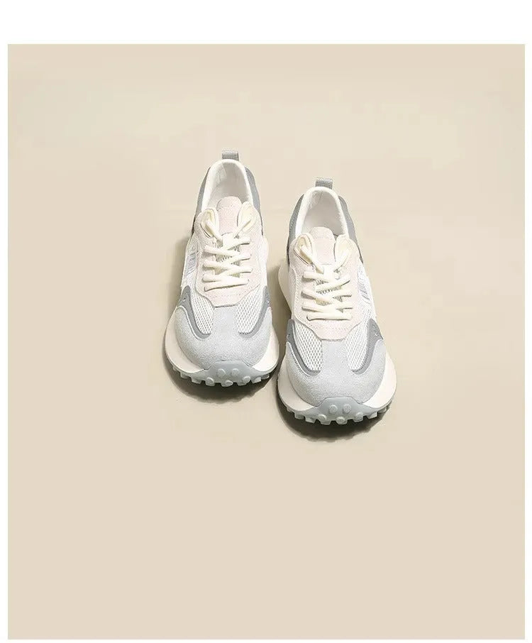 Grey and pink women's low-top retro sneakers with round toe and shallow mouth on a rubber sole.