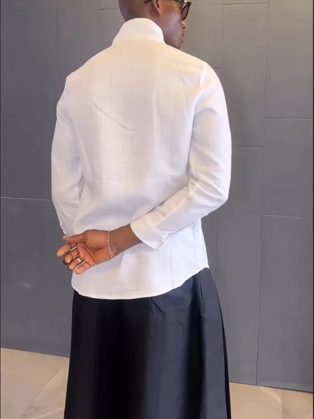 Women's white asymmetrical long sleeve shirt and black pleated trousers casual co-ordinates set on a hanger.