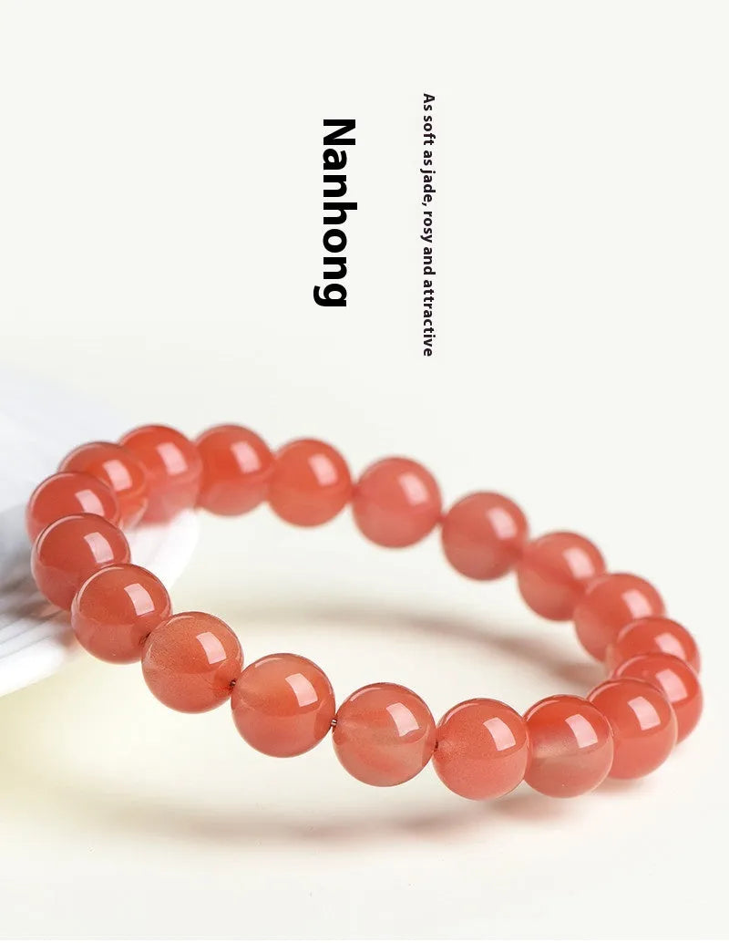 Natural cherry red agate bracelet with polished beads on a white background.