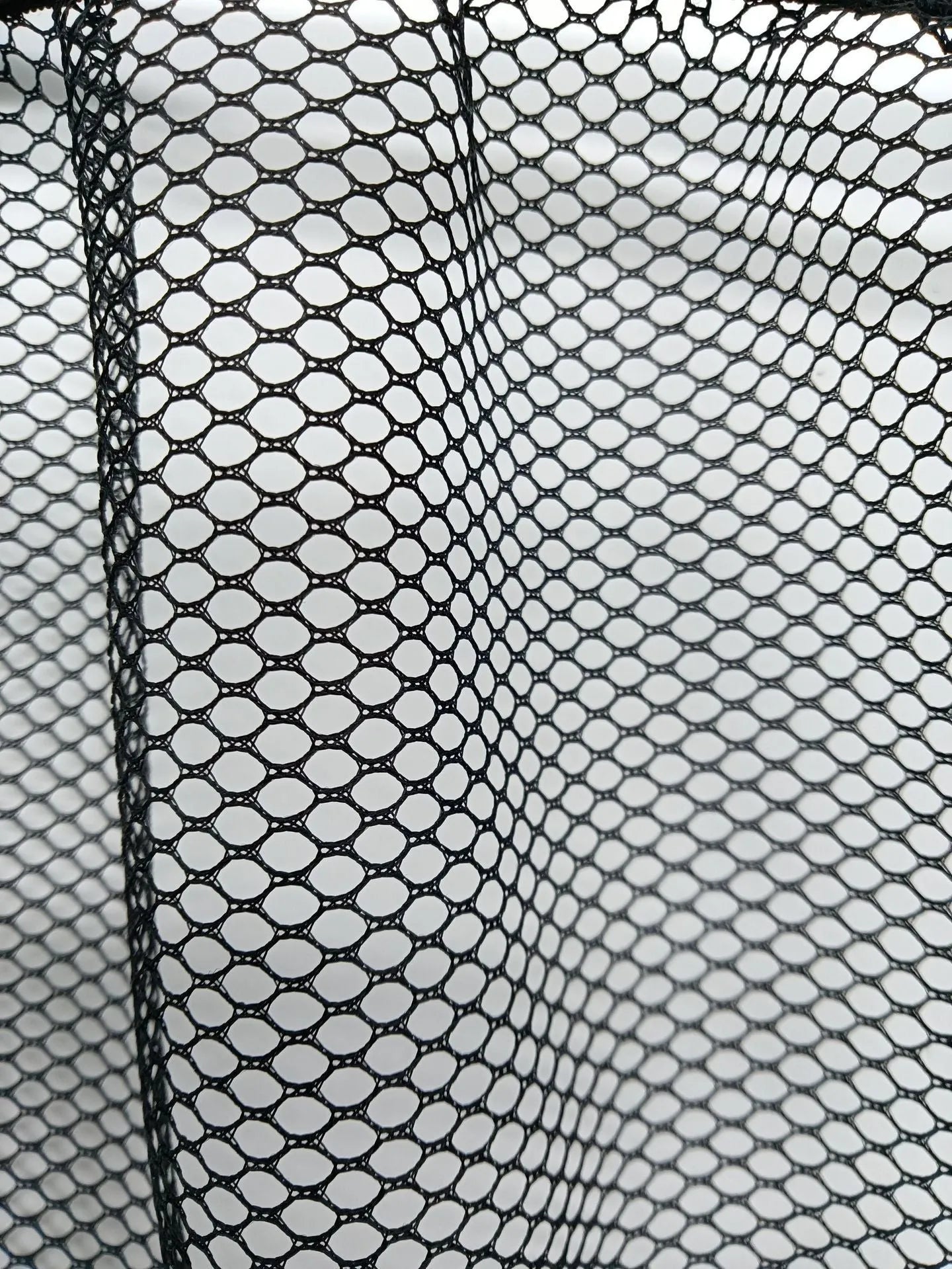 A close-up view of a black polyester elastic storage net stretched flat, showing its mesh design.