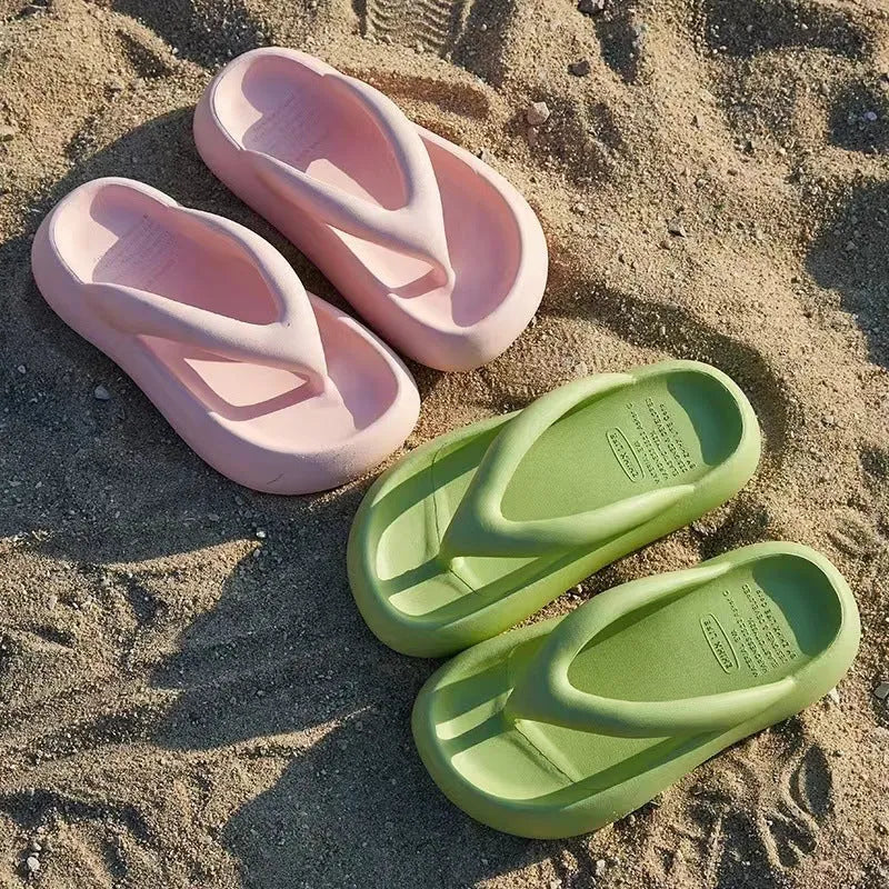 A pair of thick-soled flip-flops with a bow detail on the upper, shown in a solid colour.