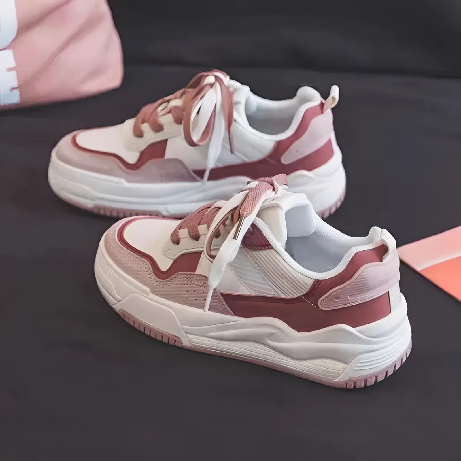 Beige and pink low-top platform sneakers with a rubber sole on a white background