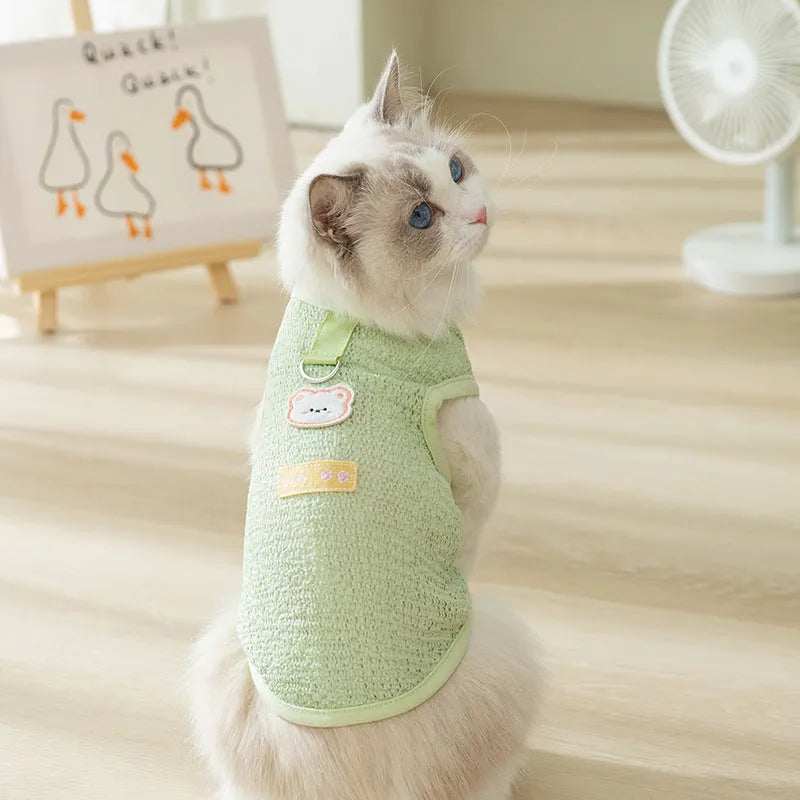 Green knitted cat clothing with a hollowed-out cartoon bear patch on the back.