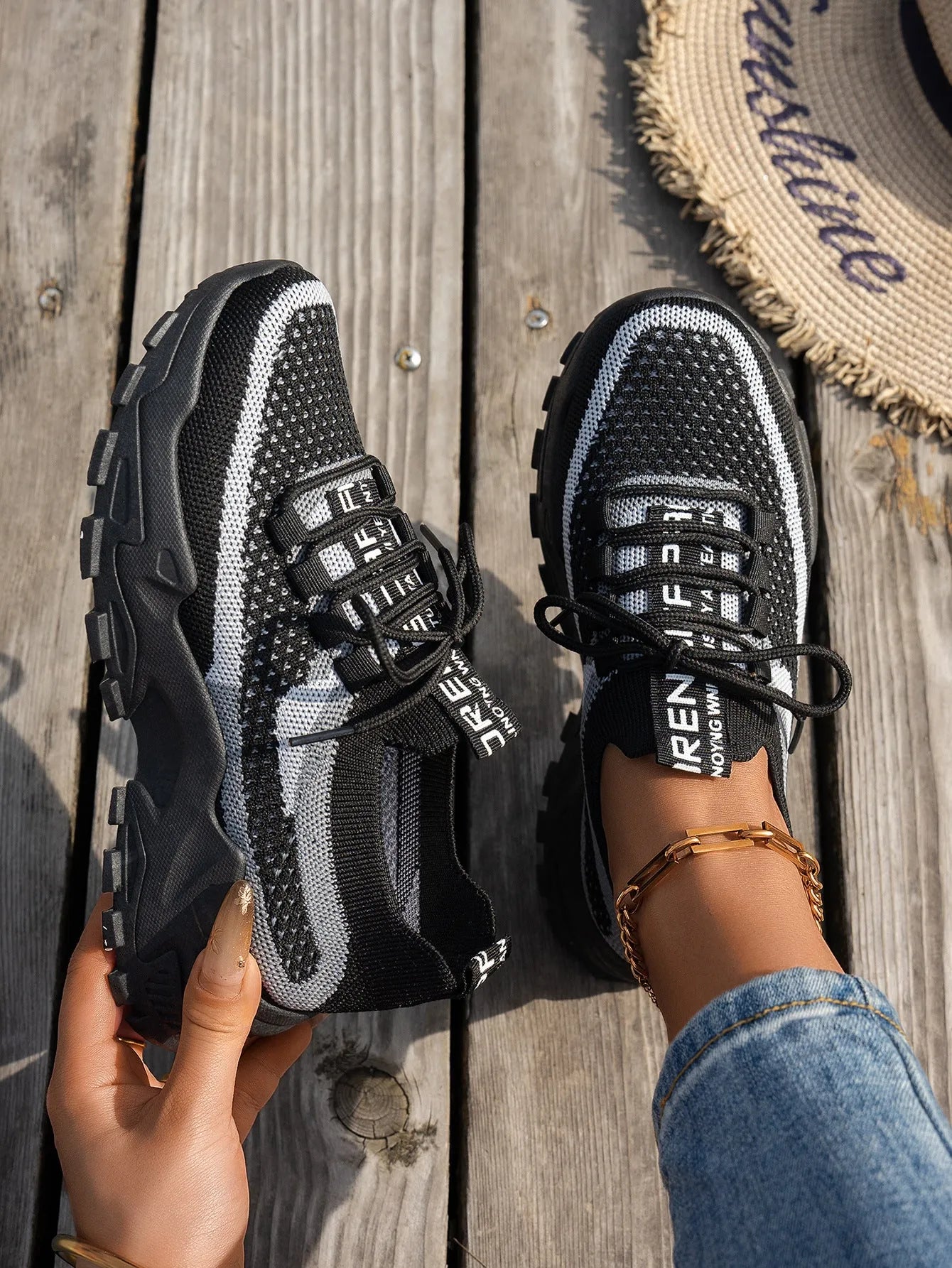 Women's Flyknit mesh sneakers in grey and white colour with flat rubber sole and lace-up front.