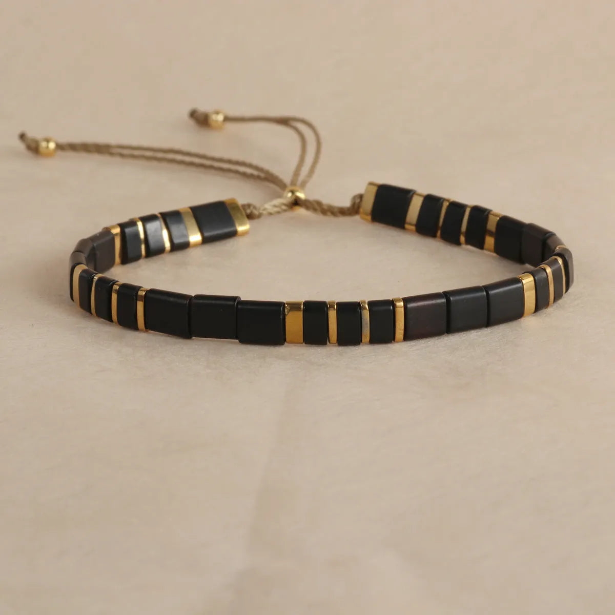 Adjustable pull beads bracelet with glass and coloured glaze beads in geometric and round shapes