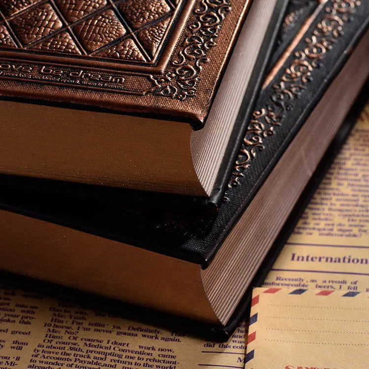 Embossed faux leather notebook in bronze colour, open to show thick white pages.