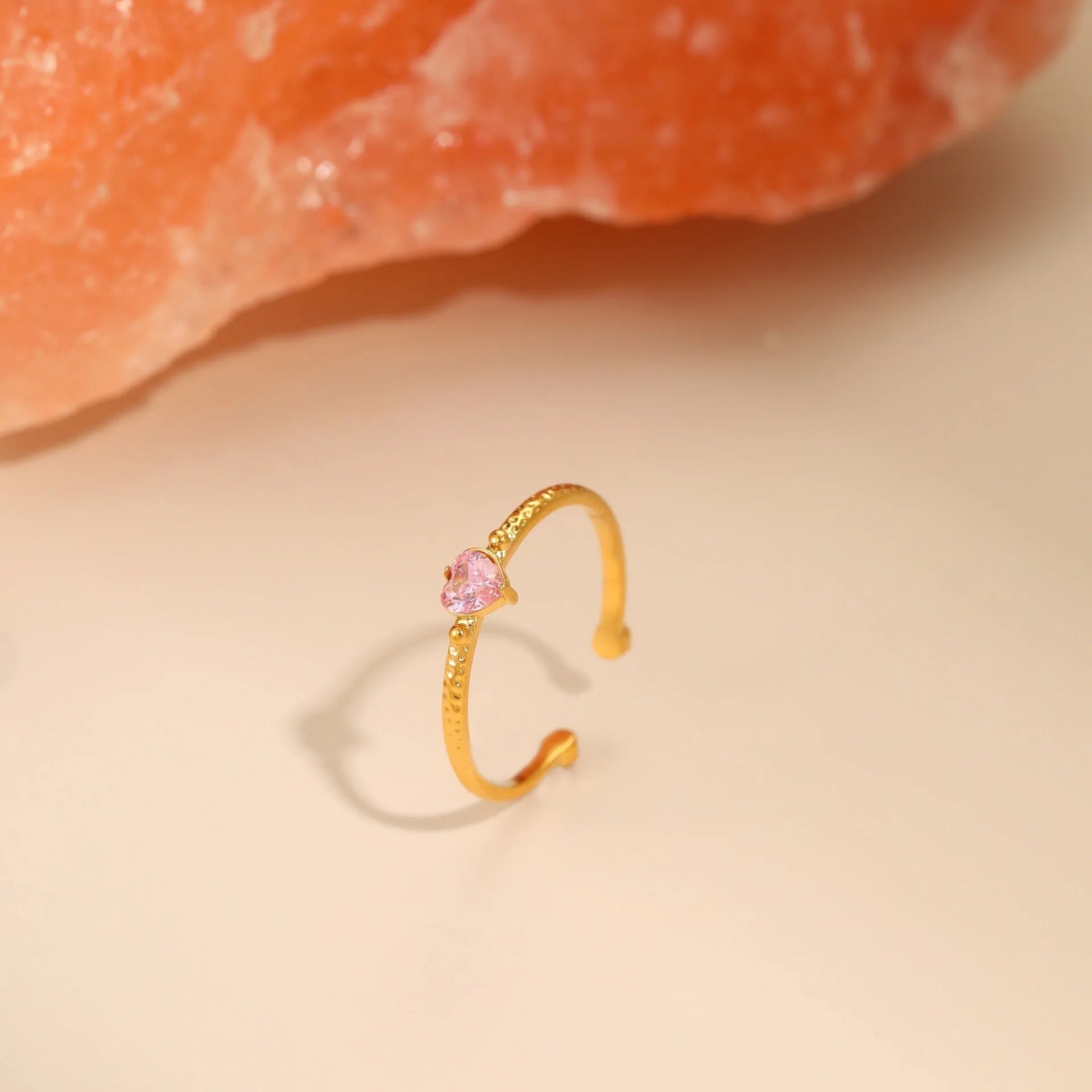 Open ended stainless steel ring with a geometric heart shape and inlaid zircon stone in white, pink, or green.