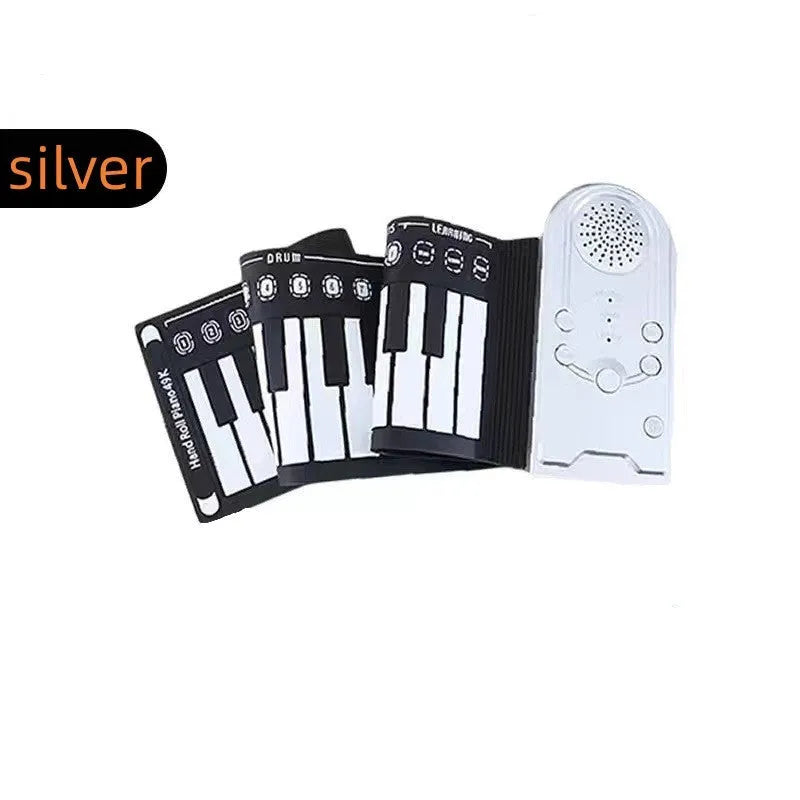 Rolled-up silicone keyboard next to black ABS control unit and speaker for portable 49-key electronic piano.