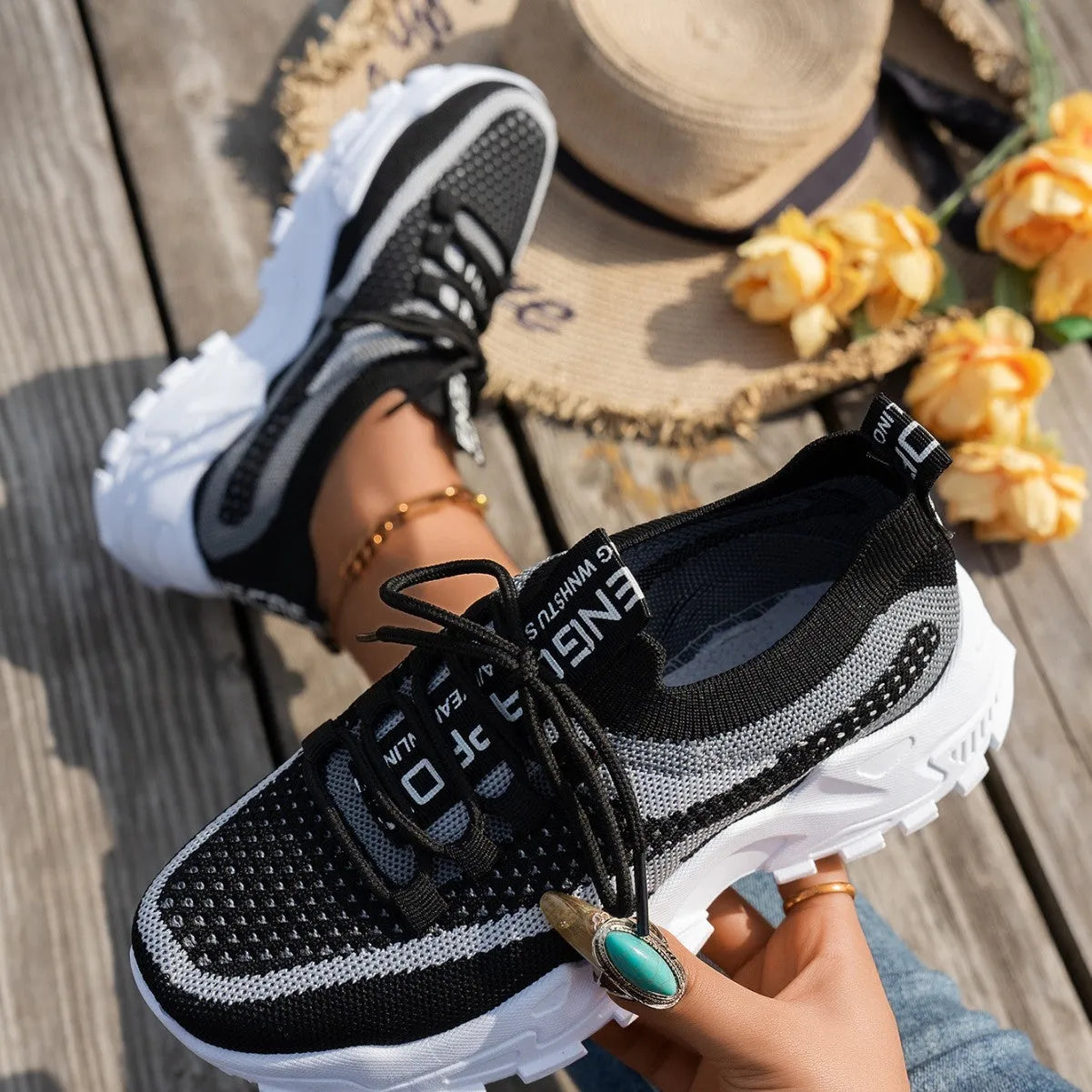 Women's Flyknit mesh sneakers in grey and white colour with flat rubber sole and lace-up front.