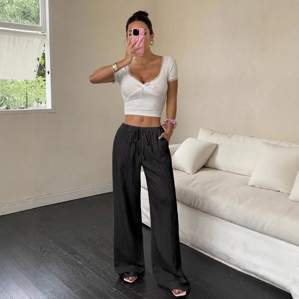 Women's wide-leg black trousers with a lace-up detail on the mid-rise waistband.