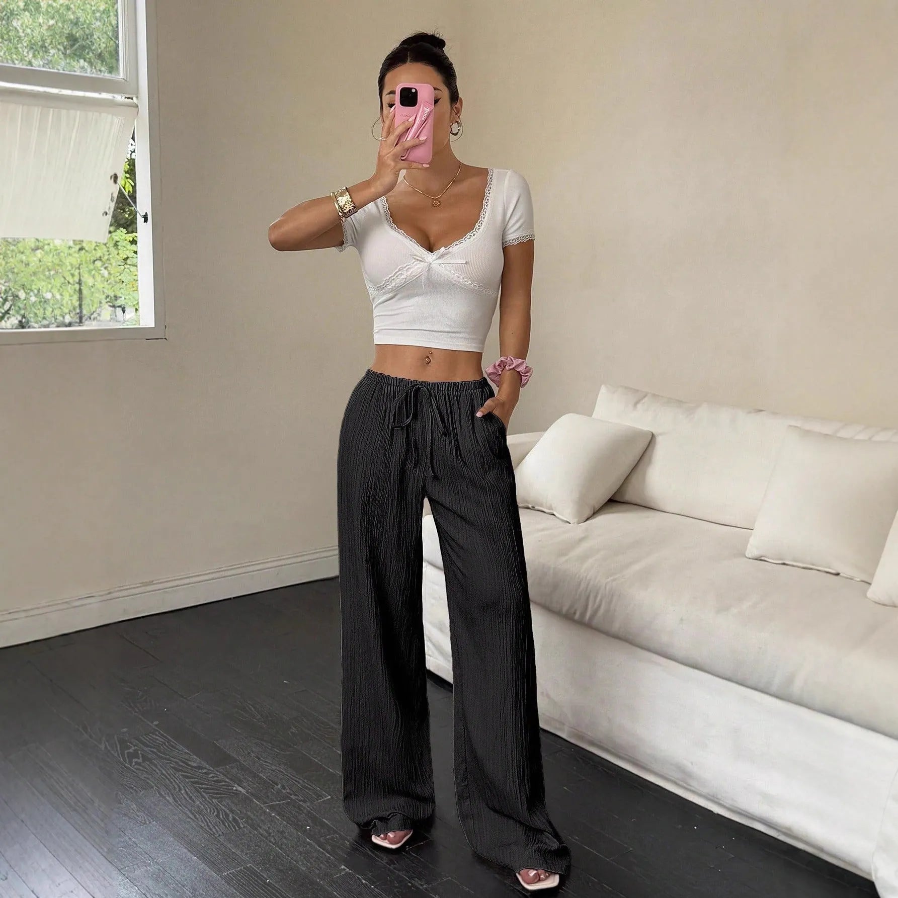 Women's wide-leg black trousers with a lace-up detail on the mid-rise waistband.