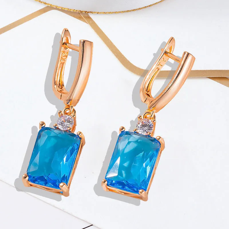 A pair of square geometric stud earrings with a gold electroplated finish on a copper base.