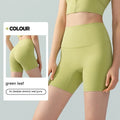 Women's high-waisted Lycra yoga shorts in leaf green, showing anti-exposure construction and short length.