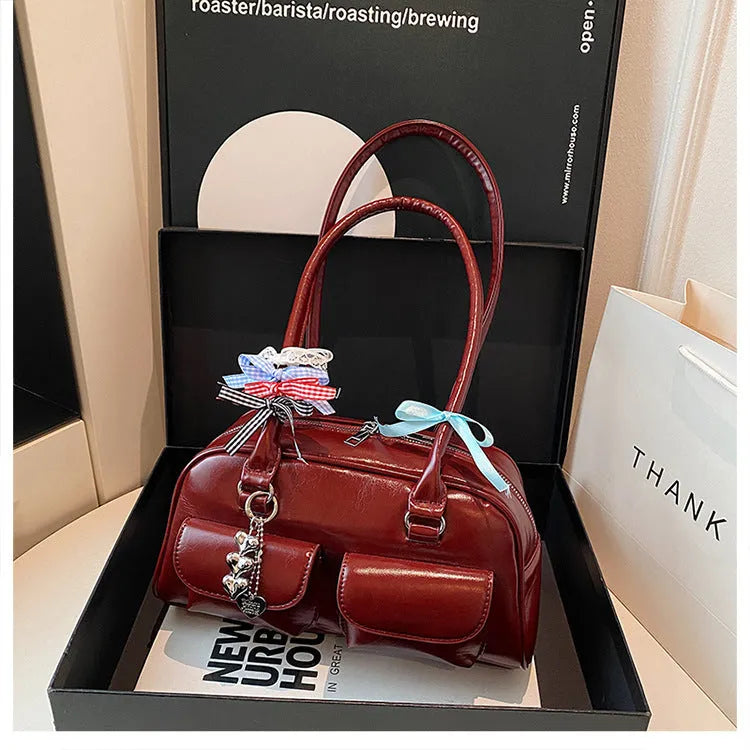 Brown PU leather retro pillow bag for women with a flap closure and double shoulder strap.