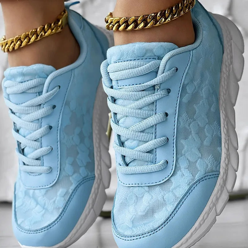 Women's white canvas running shoe with flat heel and round toe on a neutral background.