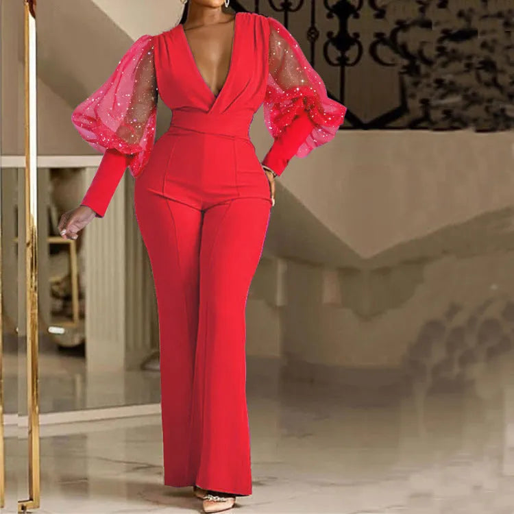 Red long sleeve women's jumpsuit with slim bodice, wide legs, and elasticated waist.
