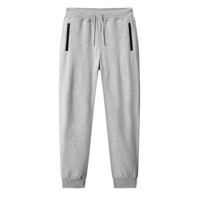 Men's thin leisure tapered knitted pants in black with ankle tie, standing on a neutral background