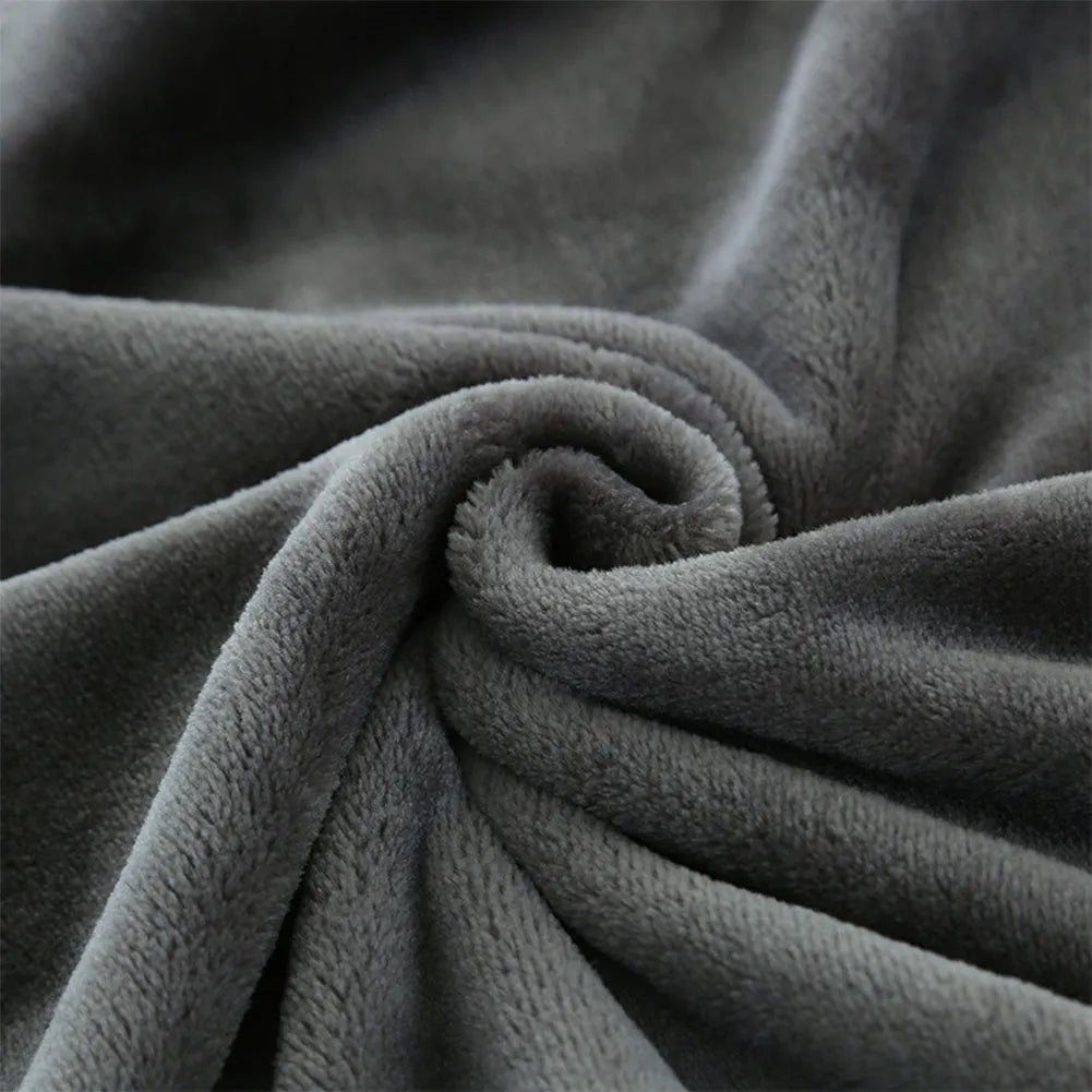 Grey tweed electric heating blanket on a bed, showing simple solid colour design