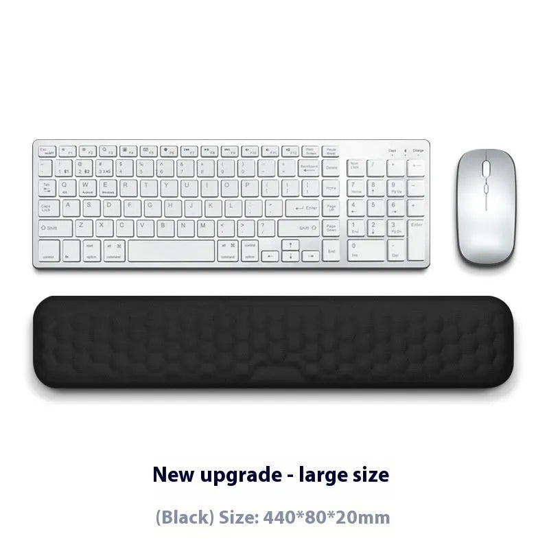 Customisable memory foam mouse wrist pad with black cloth cover on a desk.