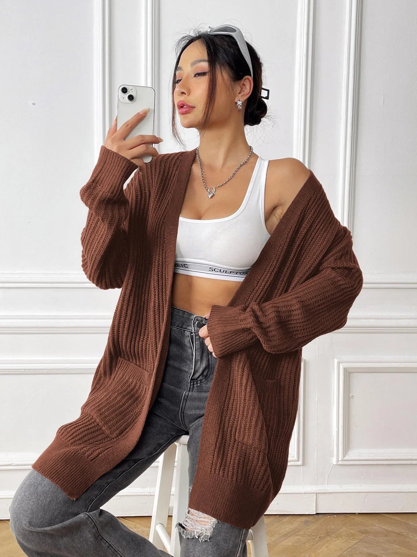 Women's dark green double pocket cardigan with long sleeves and loose fit.