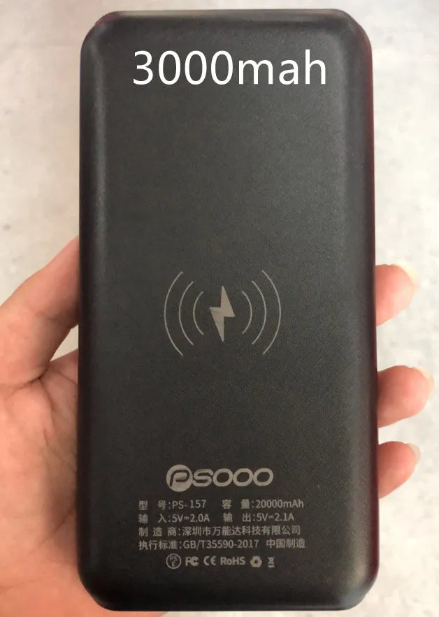 Black portable power bank with wireless charging pad on top, three USB ports, and an LED flashlight.