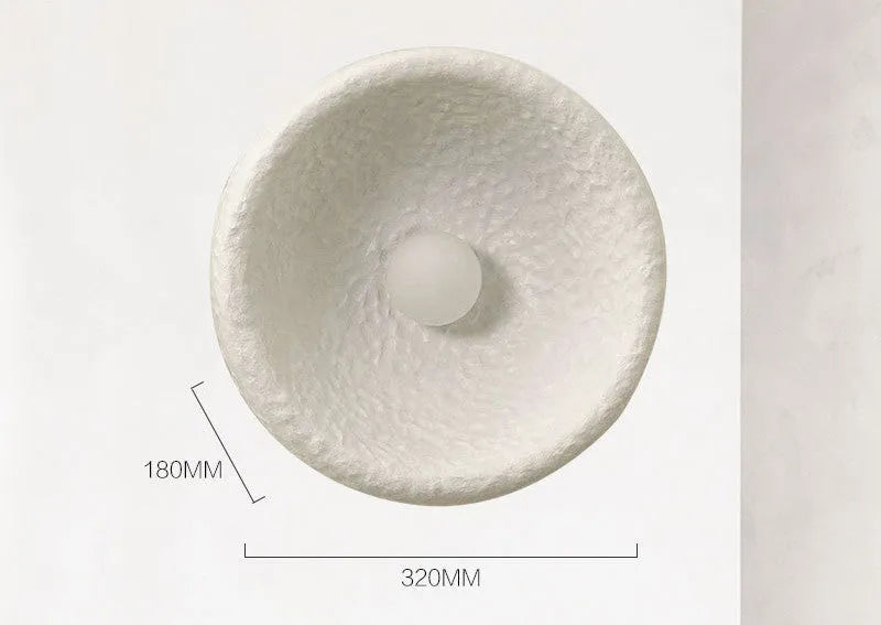 Japanese-style simple silent wall lamp with white resin shade on a wall.