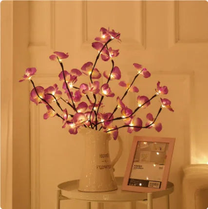 Pink Phalaenopsis orchid branch shaped LED decorative light on a table.