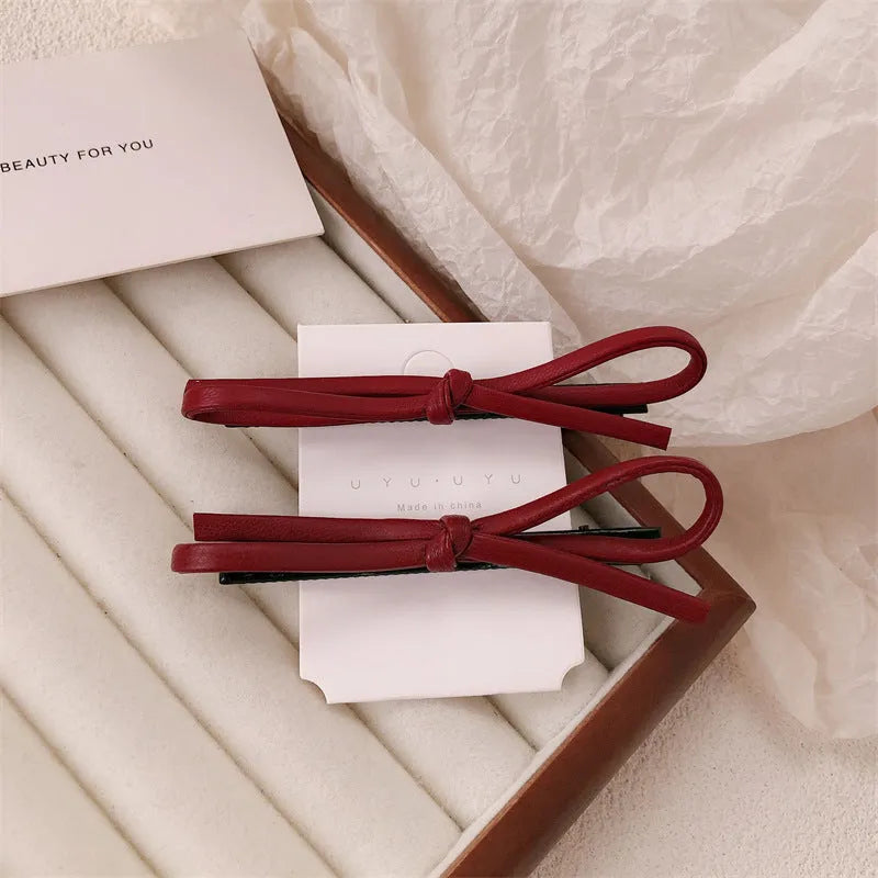 Wine red leather bow barrettes for women with handmade construction and clip mechanism