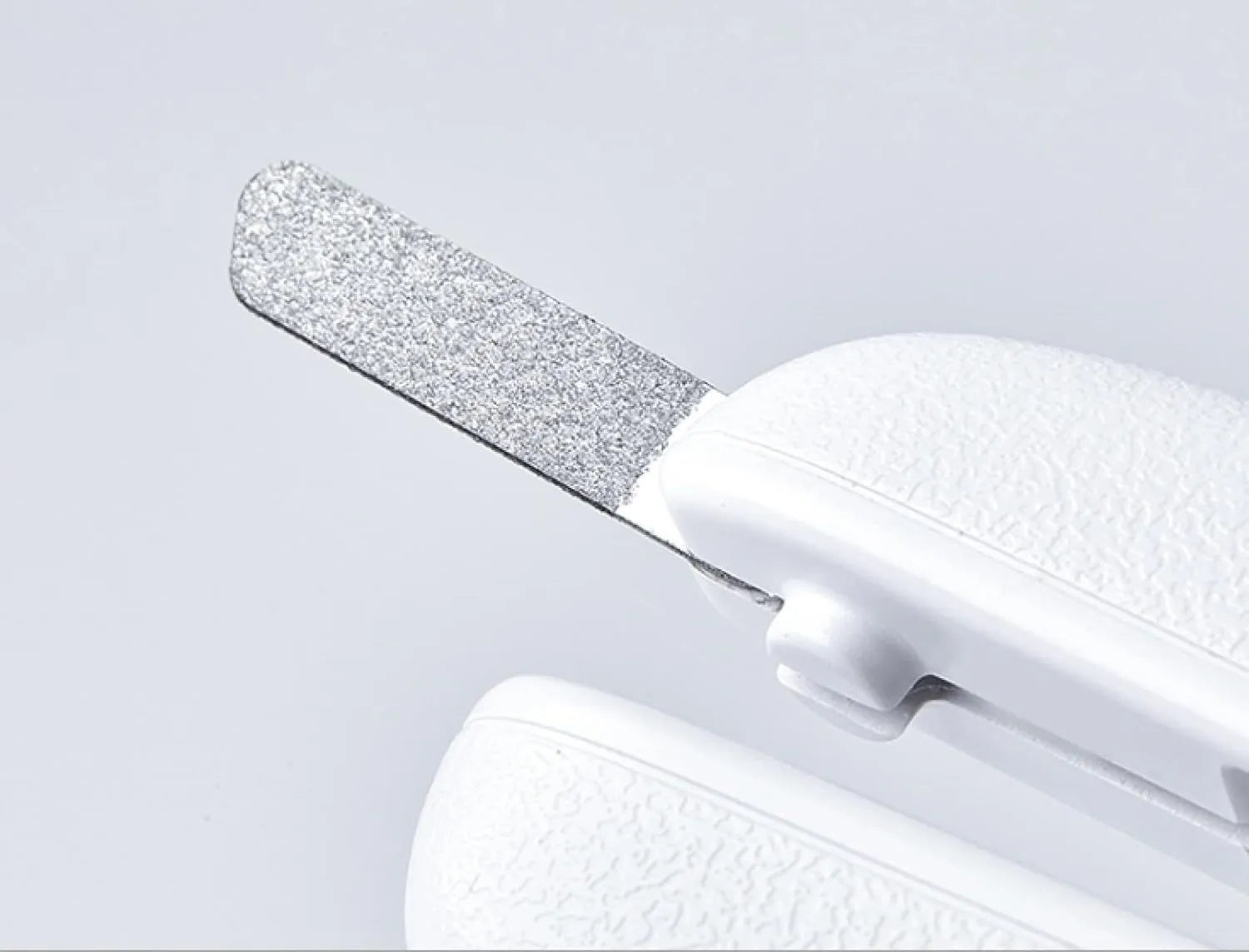White pet nail clippers with LED light, transparent anti-splash baffle, and a nail file.