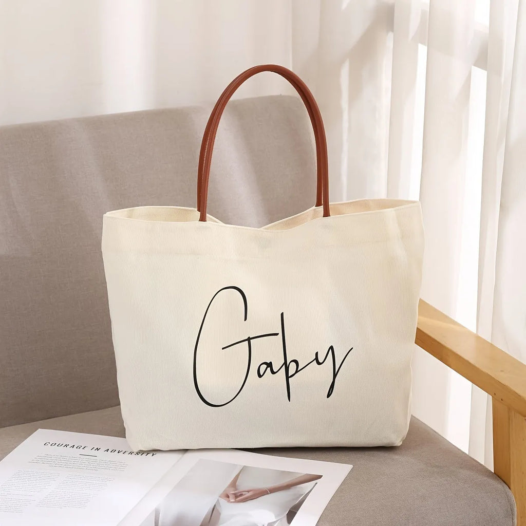 Heavyweight beige white canvas tote bag with reinforced handles on a plain background