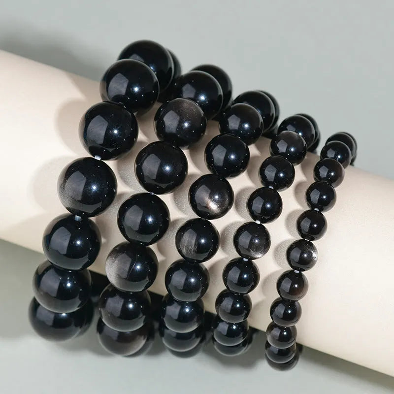 Hand-woven obsidian couple bracelet showing spherical black crystal beads in continuous strand construction