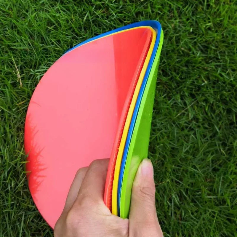 Yellow TPE football training target disc on grass, 23cm diameter flat landmark pad