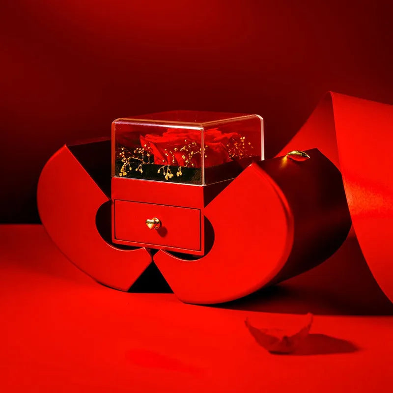 Red apple-shaped jewelry box with eternal soap flower rose and silver necklace inside
