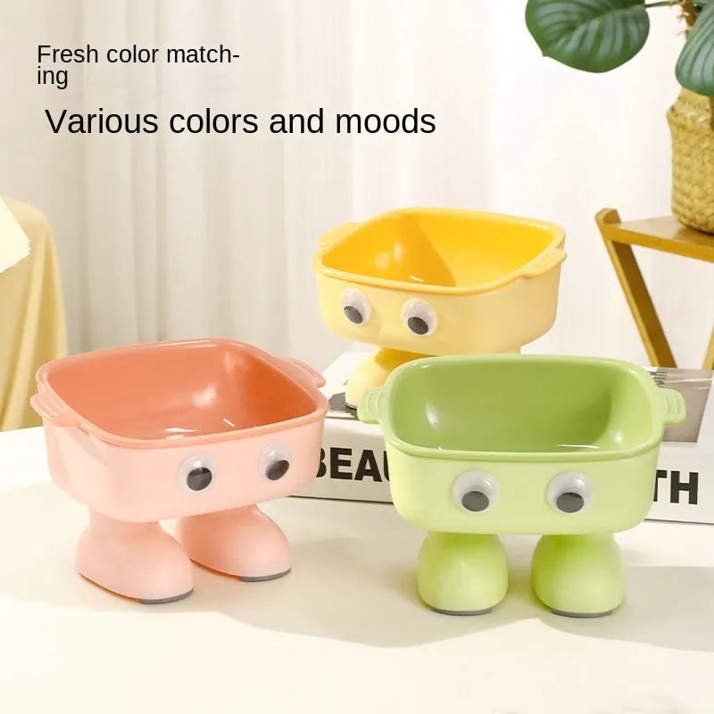 Green robot-shaped elevated cat bowl with tilted dish and anti-slip base.