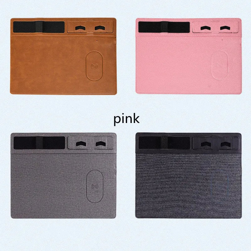 Large pink wireless charging mouse pad with integrated mobile phone holder on a desk.