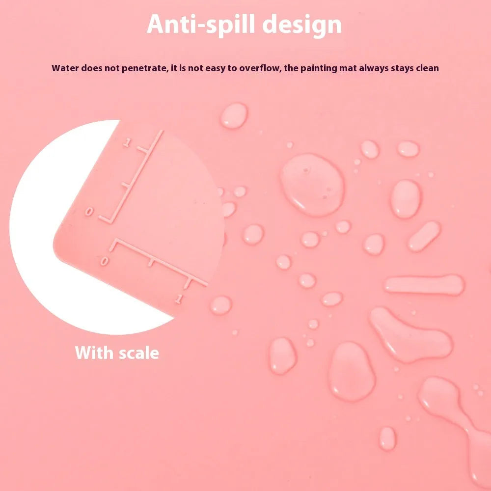 Light blue silicone painting mat with an integrated bowl on one side, positioned on a wooden table.