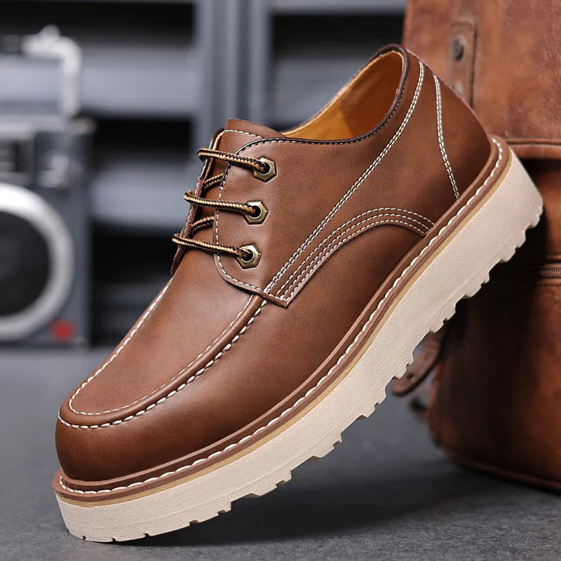 Men's black low-top Martin boots with round toe and rubber sole on a neutral background