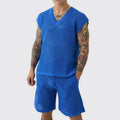 Man wearing a blue sleeveless vest and matching shorts from a men's cotton-blend sports suit set.