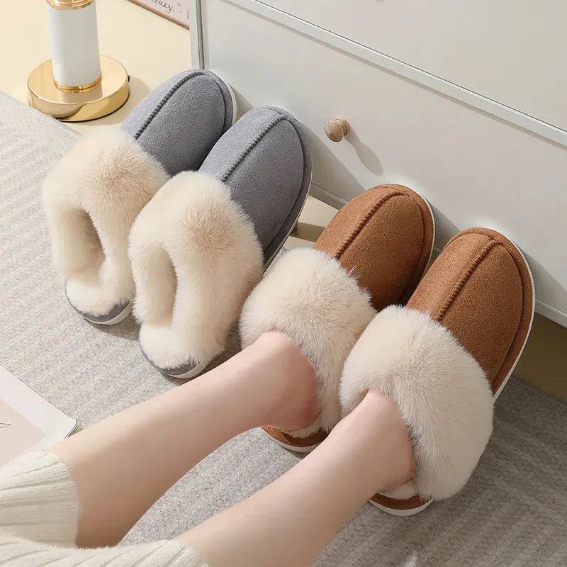 Women's brown plush indoor slippers with round toe, flat heel, and decorative stitching.