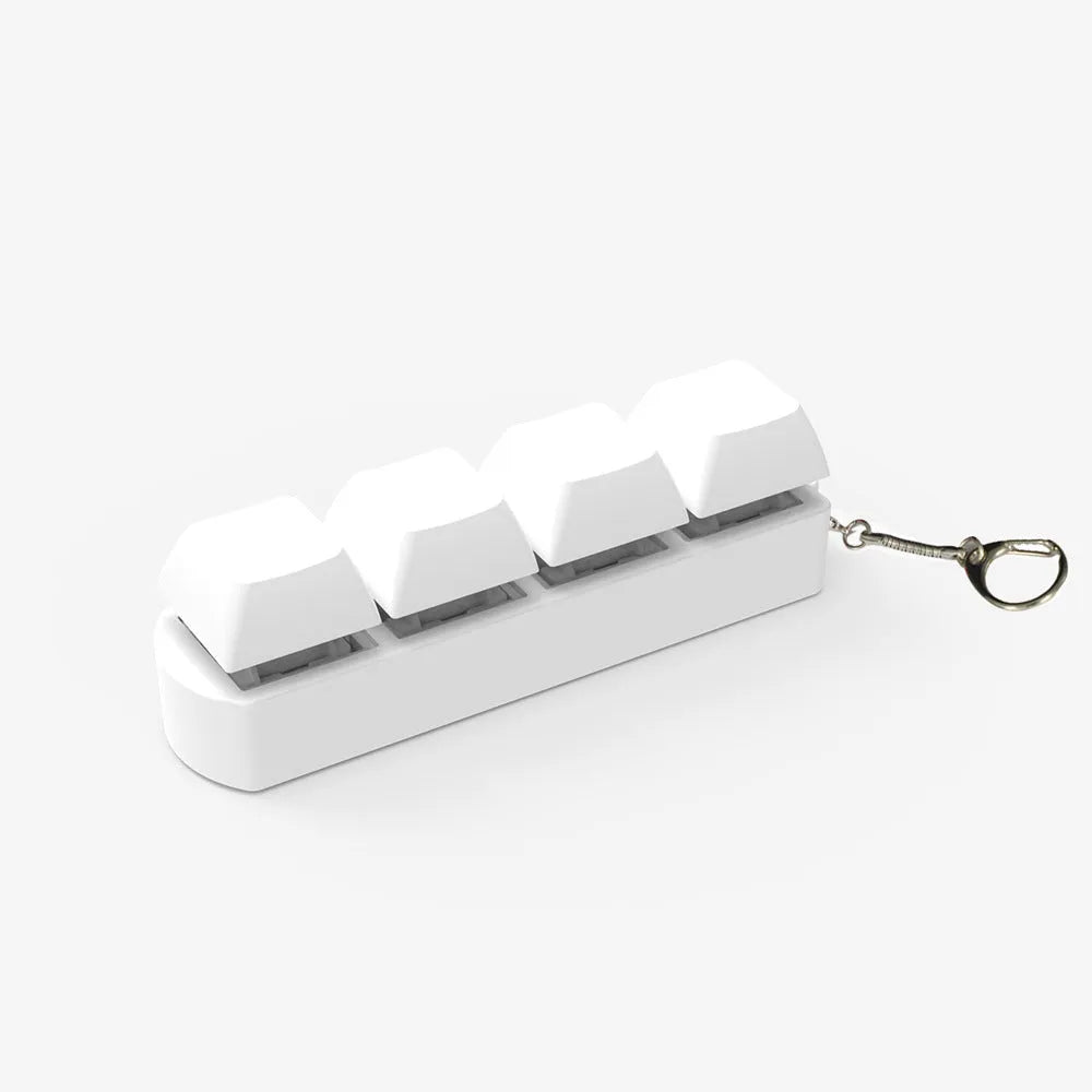Four-key mechanical keyboard switch tester made of ABS plastic on a desk.