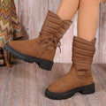 Women's black suede snow boots with chunky heel and lace-up design, shown on a foot.