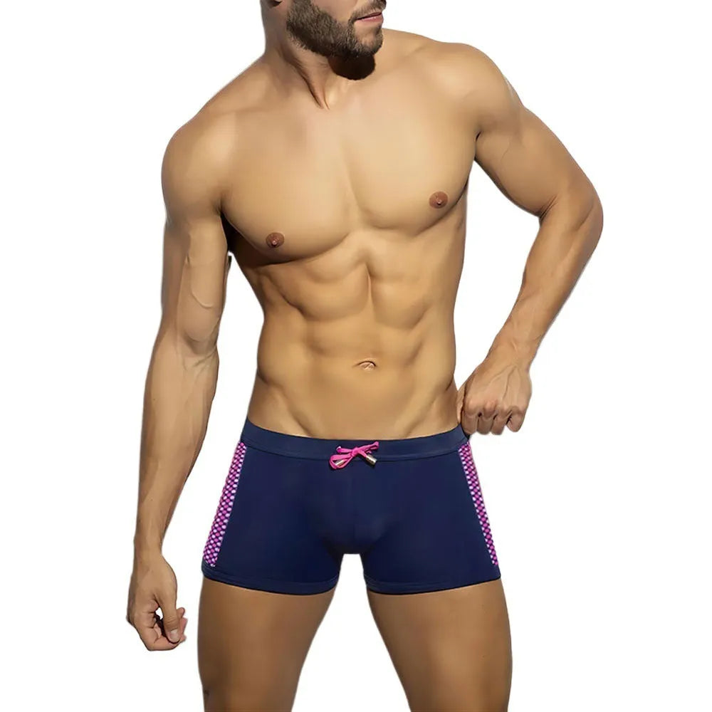 Men's black swimming boxers with white polka dot print and ribbon trim, laid flat.