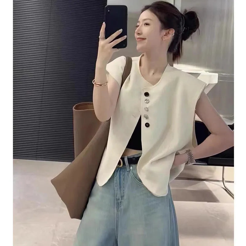 Women's loose-fit short-length polyester vest in milky white colour with front pockets.