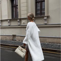 White women's longline cardigan jacket with long sleeves, loose fit.