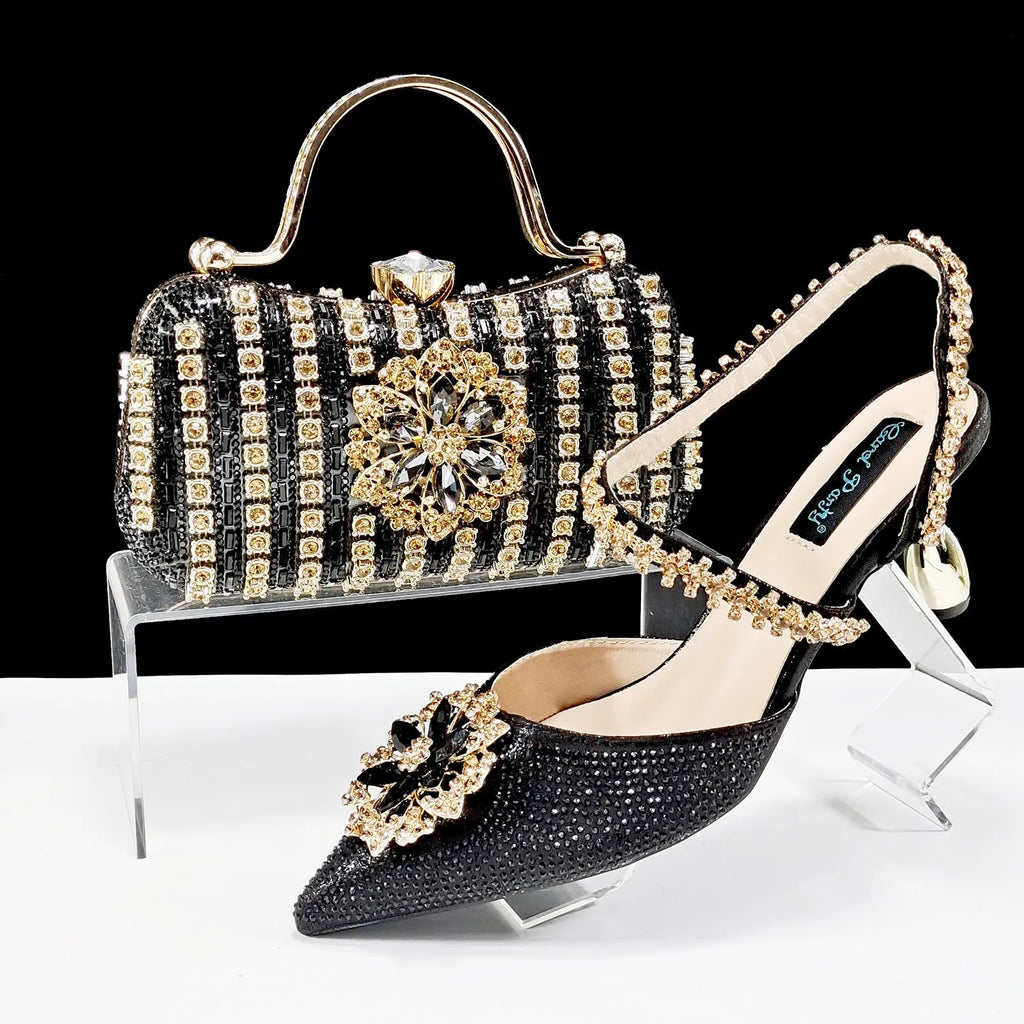Women's black synthetic leather high-heel shoes with rhinestone ankle chain and matching hard clutch bag.